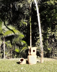 uma corujinha e um pote de madeira na grama